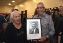 The late Lt. Col. George Saunderson's children, Irene and Jim, holding a picture of their father at the night in Teemore.