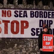 A protester outside Larchfield Estate where the DUP are holding a private party meeting, they are calling for the DUP not to go back into Stormont until the Irish Sea Border is removed. Image: PA