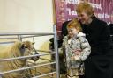 Hollie Keys, watched by Mrytle Abercromie, makes friends with the sheep at the Harvest Service.
