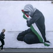 A woman walks past a pro-Palestine mural by the artist Emmalene Blake in the Harold's Cross area of Dublin. Picture date: Tuesday November 7, 2023. PA Photo. See PA story POLITICS IsraelIreland. Photo credit should read: Niall Carson/PA Wire
