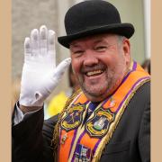 Bro. Mervyn Byers, County Grand Master, waving to the crowds during 2023's Twelfth Celebrations in Ballinamallard. Photo by John McVitty.
