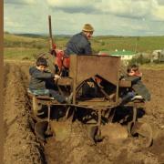 Pictured are Michael Mc Girr and his daughters Marie and Bernie planting potatoes in the townland of Bigh in 1977.