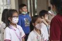 Staff members check students' body temperatures upon their arrival at Jakarta Nanyang School in Serpong on the outskirts of Jakarta, Indonesia, Tuesday, March 3, 2020. Indonesia confirmed its first cases of the coronavirus Monday in two people who con