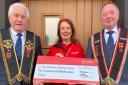 Air Ambulance volunteer Hazel McClelland receiving a cheque for £250 from Hazlett Moore (left) and Derek Anderson (right) of Tubrid Royal Marksmen RBP 1235. The money raised from car parking at the RBP parade in Kesh in August.