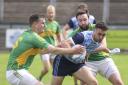 Lawrence McKeown is tackled by Tiarnán Daly and Liam McQuaid.