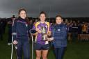 Derrygonnelly's joint captains Erin Flanagan and Andrea Gordon being presented with the Senior League winners trophy by Tanya Rhatigan.