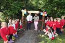 Mr Jason Kilfedder, Principal of Lisbellaw PS and Mrs Ginn, P4 teacher cutting the ribbon to open the new Nature garden at the school wathed by P2 pupils.