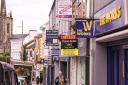 A view down the centre of Enniskillen, with retail and rental signs in focus.