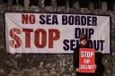 A protester outside Larchfield Estate where the DUP are holding a private party meeting, they are calling for the DUP not to go back into Stormont until the Irish Sea Border is removed. Image: PA