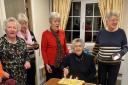 Frankie Hornby (99) cutting her birthday cake with friends.