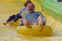 Liberal Democrat leader Sir Ed Davey rides down the Ultimate Slip n Slide attraction near Frome, Somerset, while on the General Election campaign trail (Rod Minchin/PA)