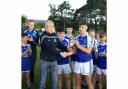 Eoghan Cassidy presents the Devenish captain, Daniel McGovern with the winners trophy