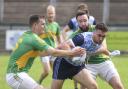 Lawrence McKeown is tackled by Tiarnán Daly and Liam McQuaid.