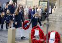 Children playing their part to help pay the community's respects at the war memorial.