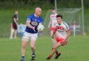 Shuan Doherty fists the ball clear before Pearse McDermott can tackle