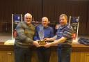 Harold Nixon and David Graham being presented with the Wesley Phair Pairs trophy by Jude Morris, representing the Phair family.
