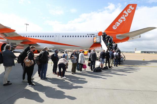 Impartial Reporter: People queue to board an EasyJet plane. (PA)
