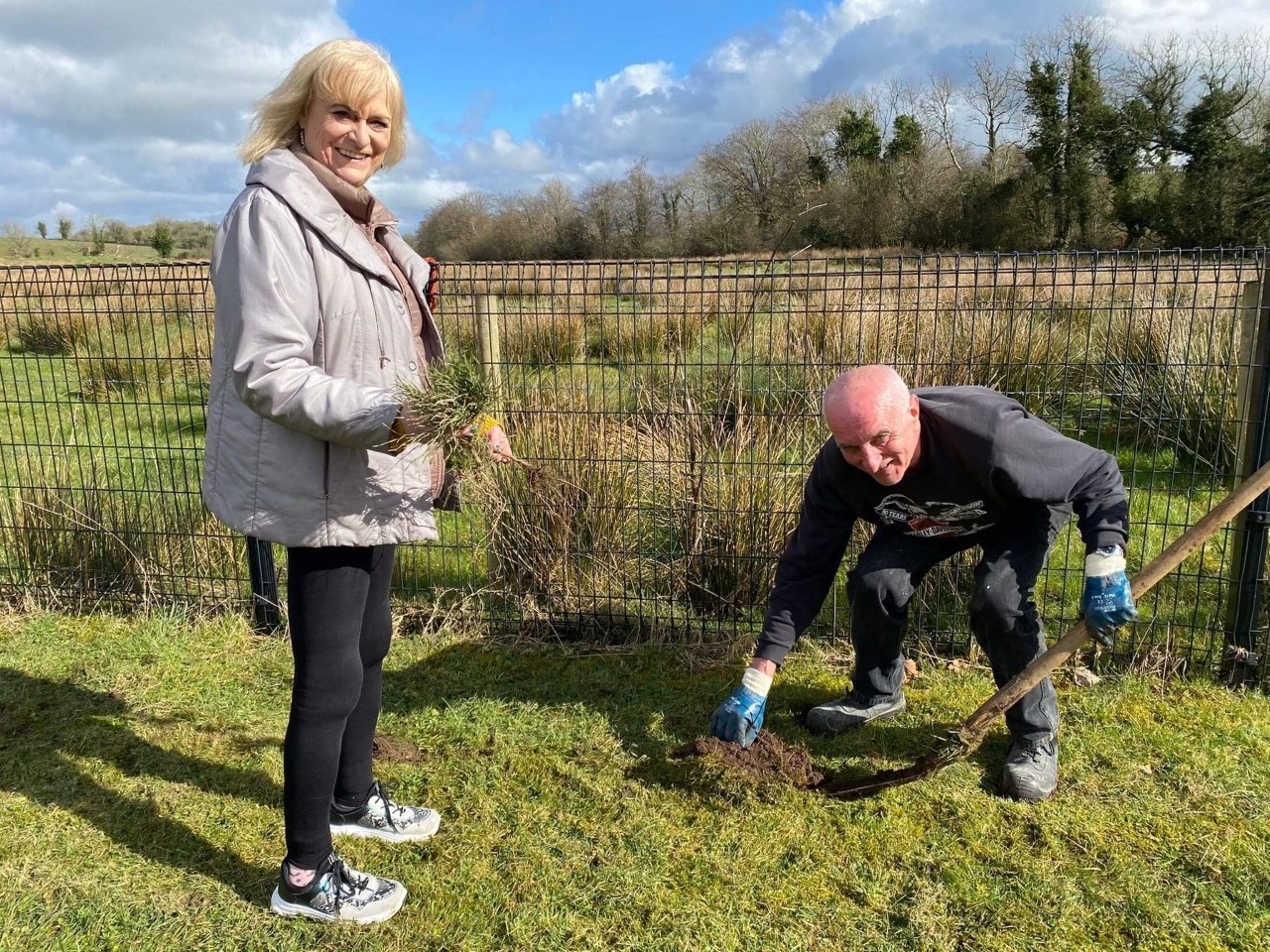 Freda Johnston instructs her husband John on how to dig a hole during the tree planting in Magheraveely.