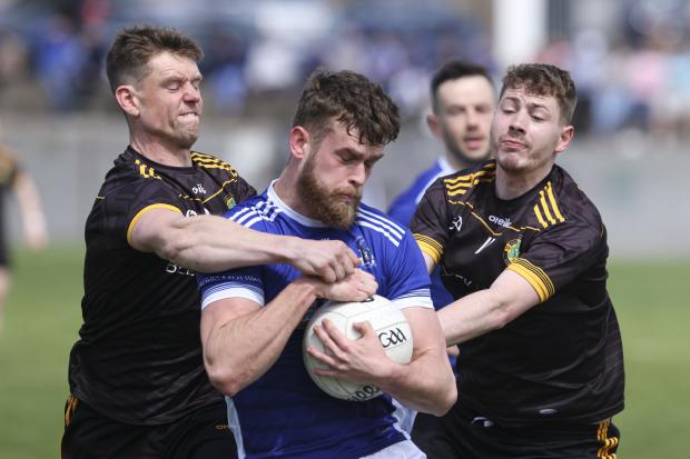 Daire Ó Catháin is tackled by Gregory McGloin and Luke Ryder.
