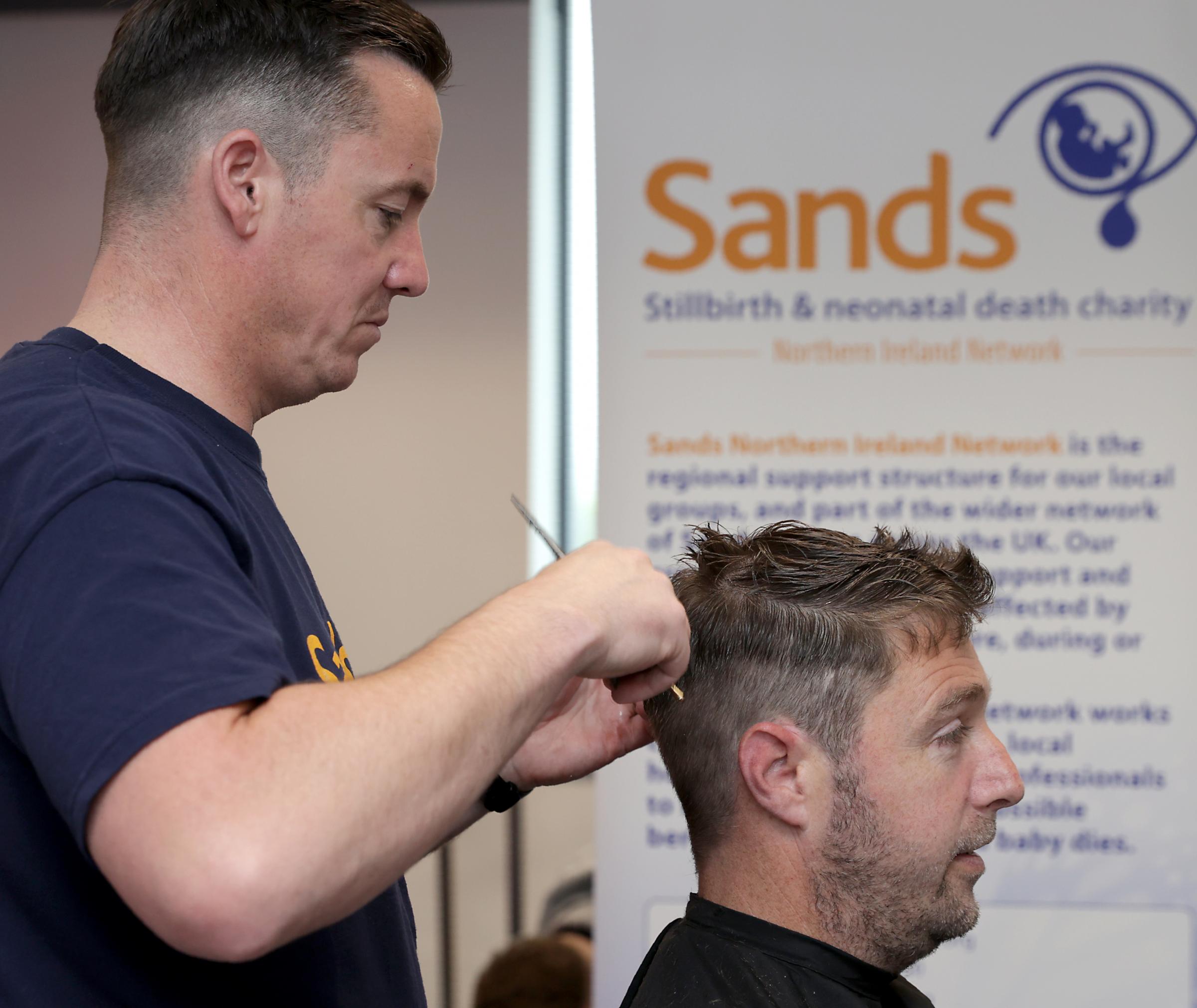 Gareth Kennedy, getting a full head haire cut from Sean Merrett, Barber, during the fundraising event at South West College.