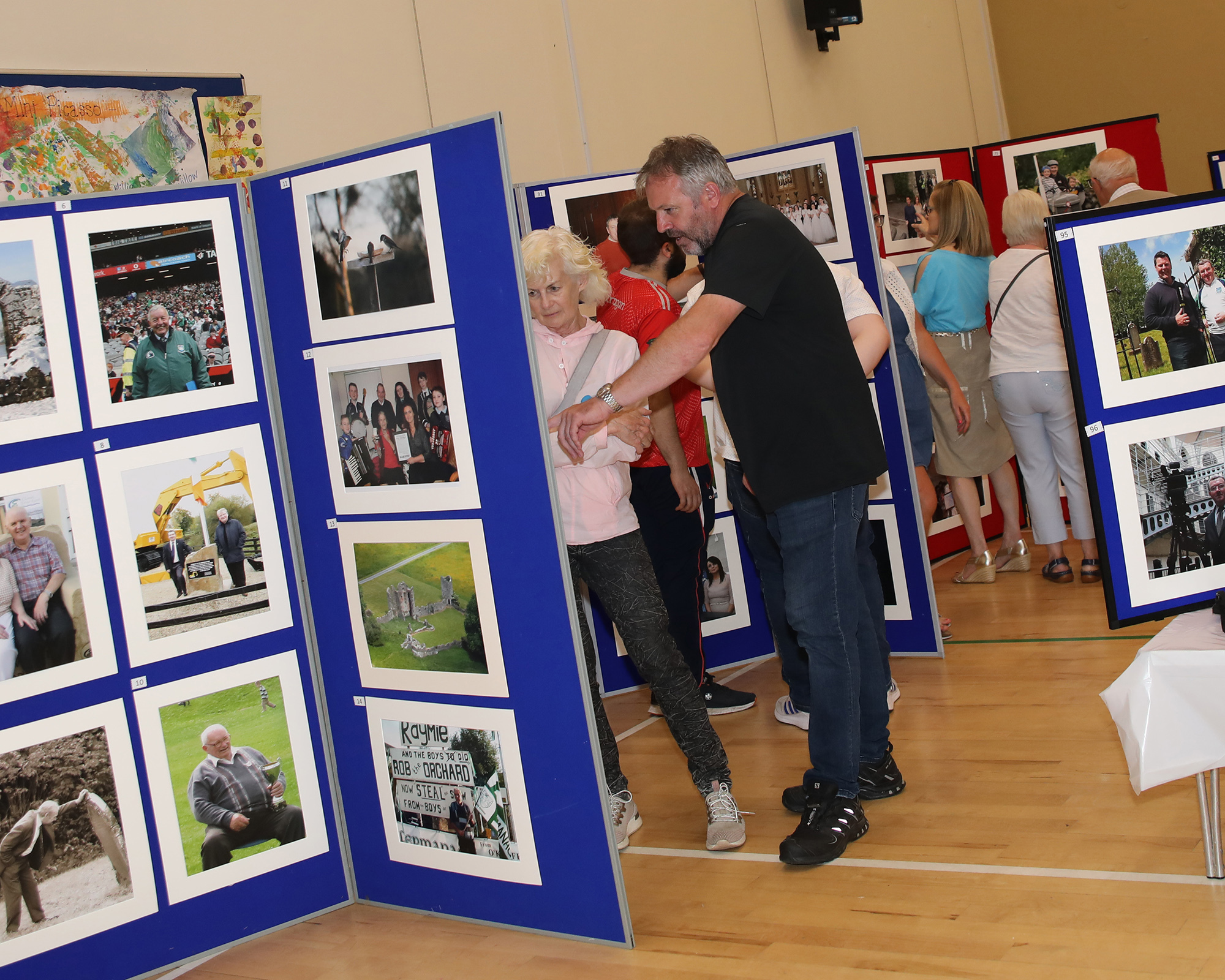 Declan Lynch and Linda Marshall looking at some of Mickeys photos in a photo exhibition of his work.