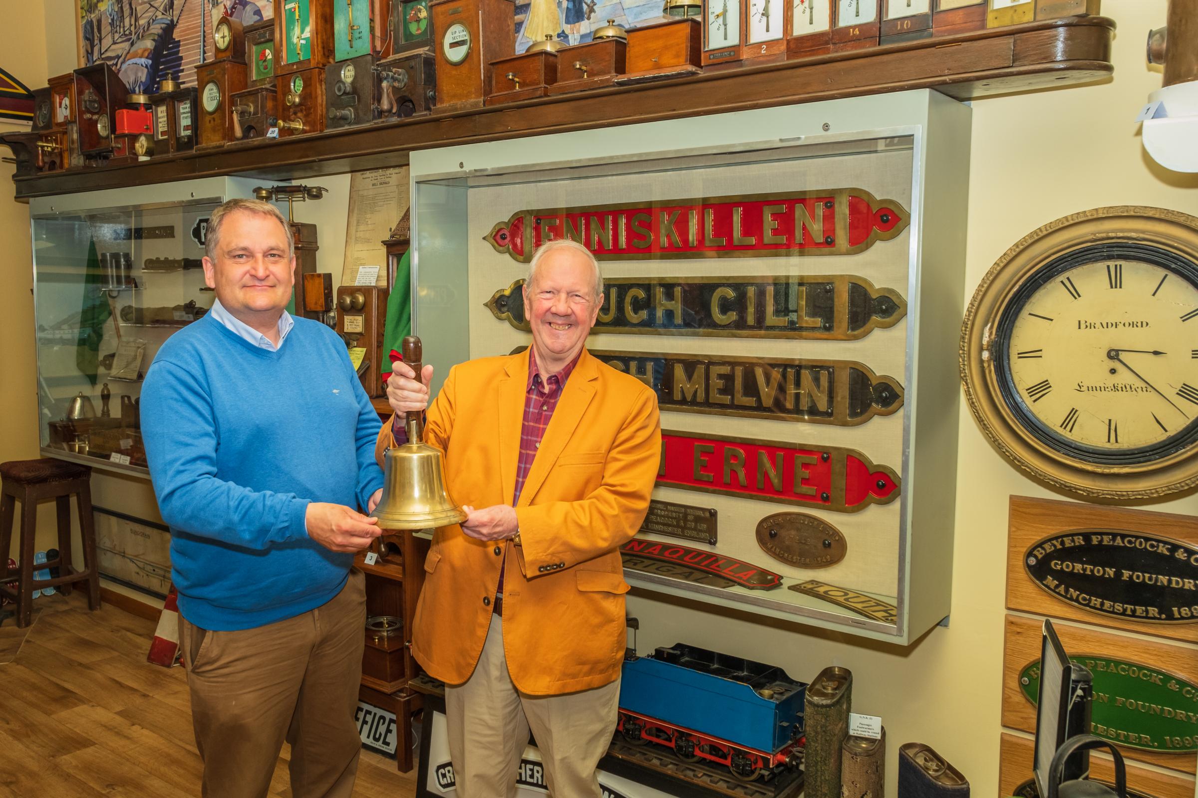 Lord Faulkner of Worcester (right) admires the handbell from Enniskillen Railway Station with Selwyn Johnston, Headhunters Railway Museum volunteer.