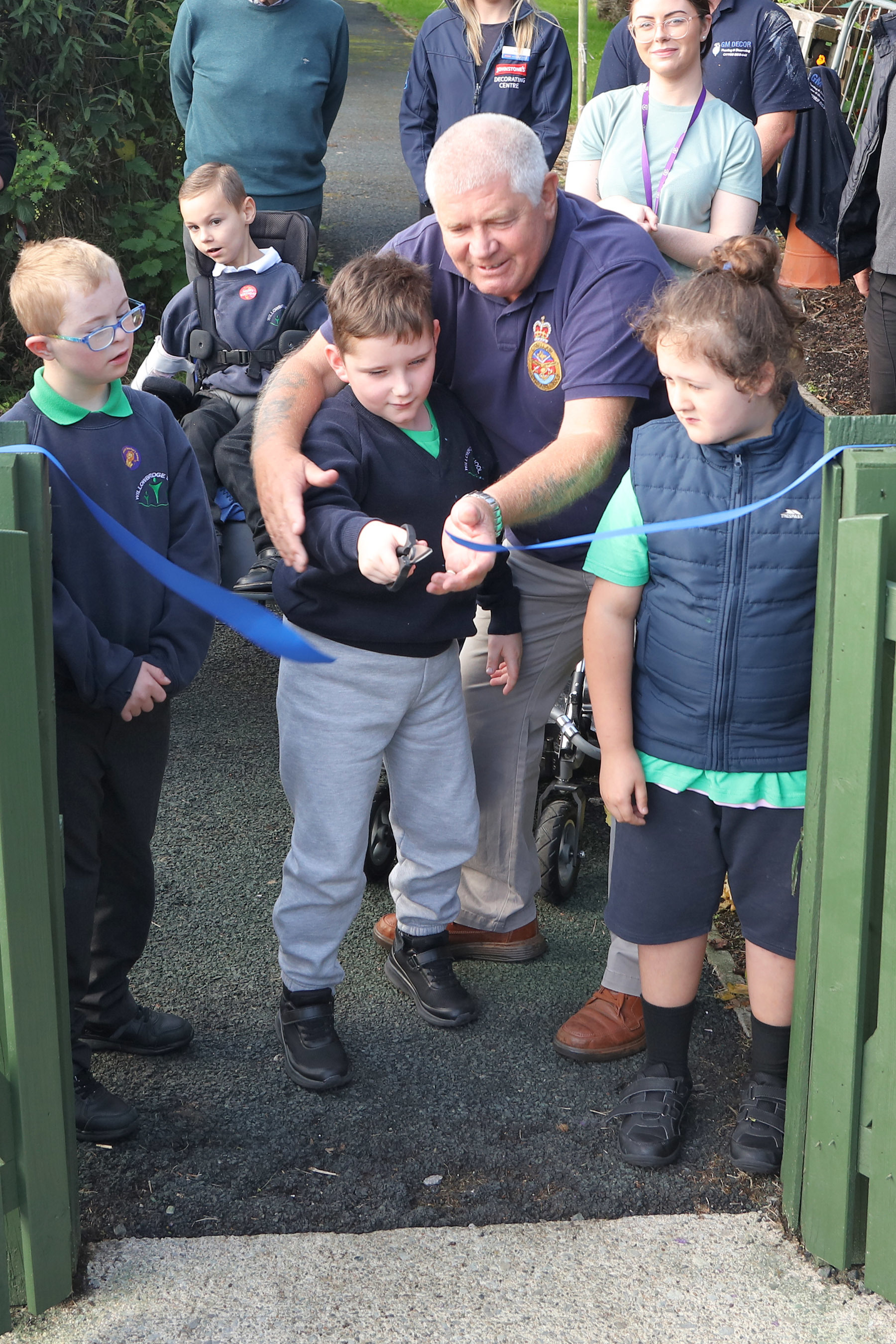 Charlie Rice, a pupil in Willowbridge school cutting the tape into the sensory garden.
