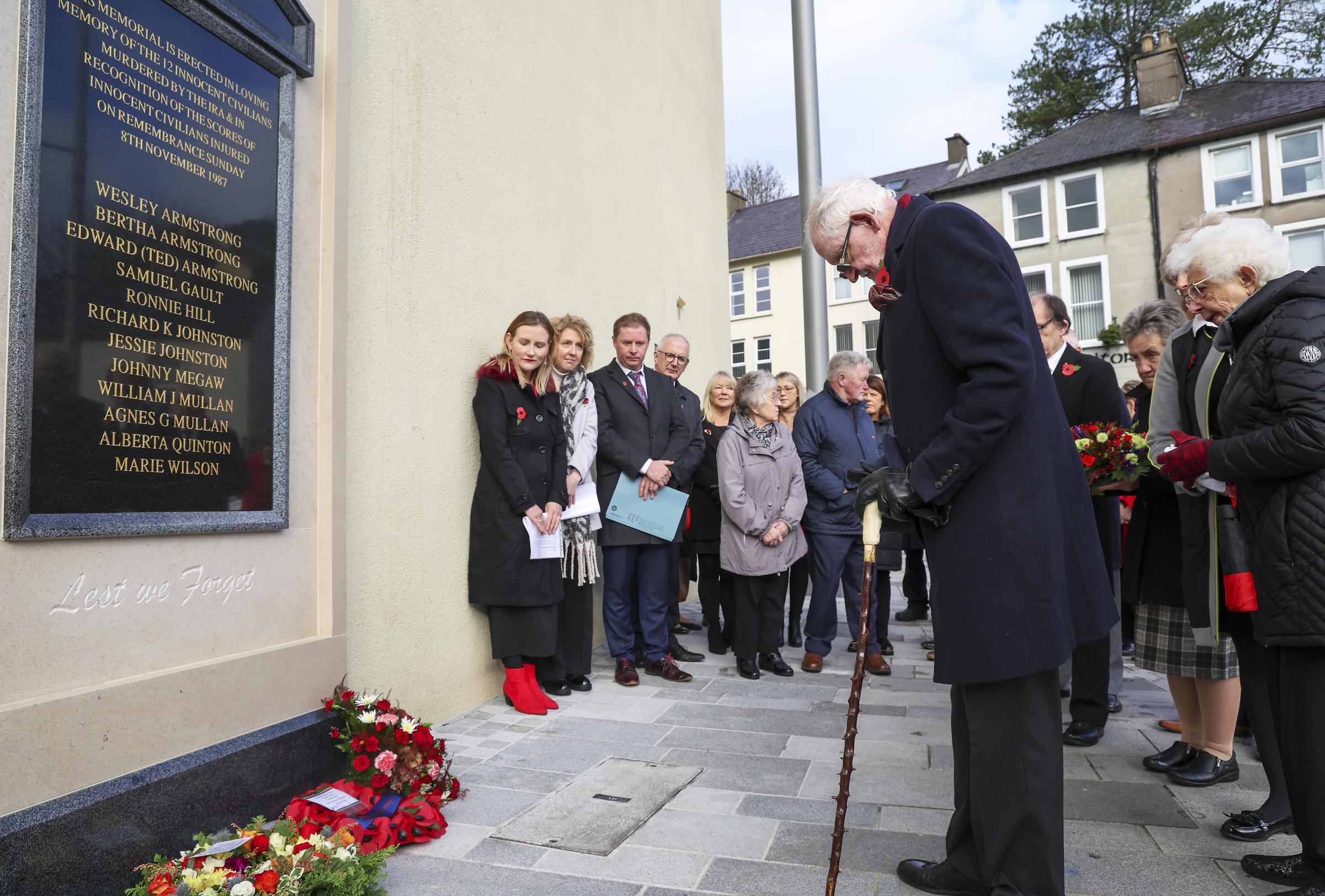 Jim Dixon, the most seriously injured person to survive the Enniskillen bomb bows his head after laying a wreath at the new Memorial in Enniskillen.