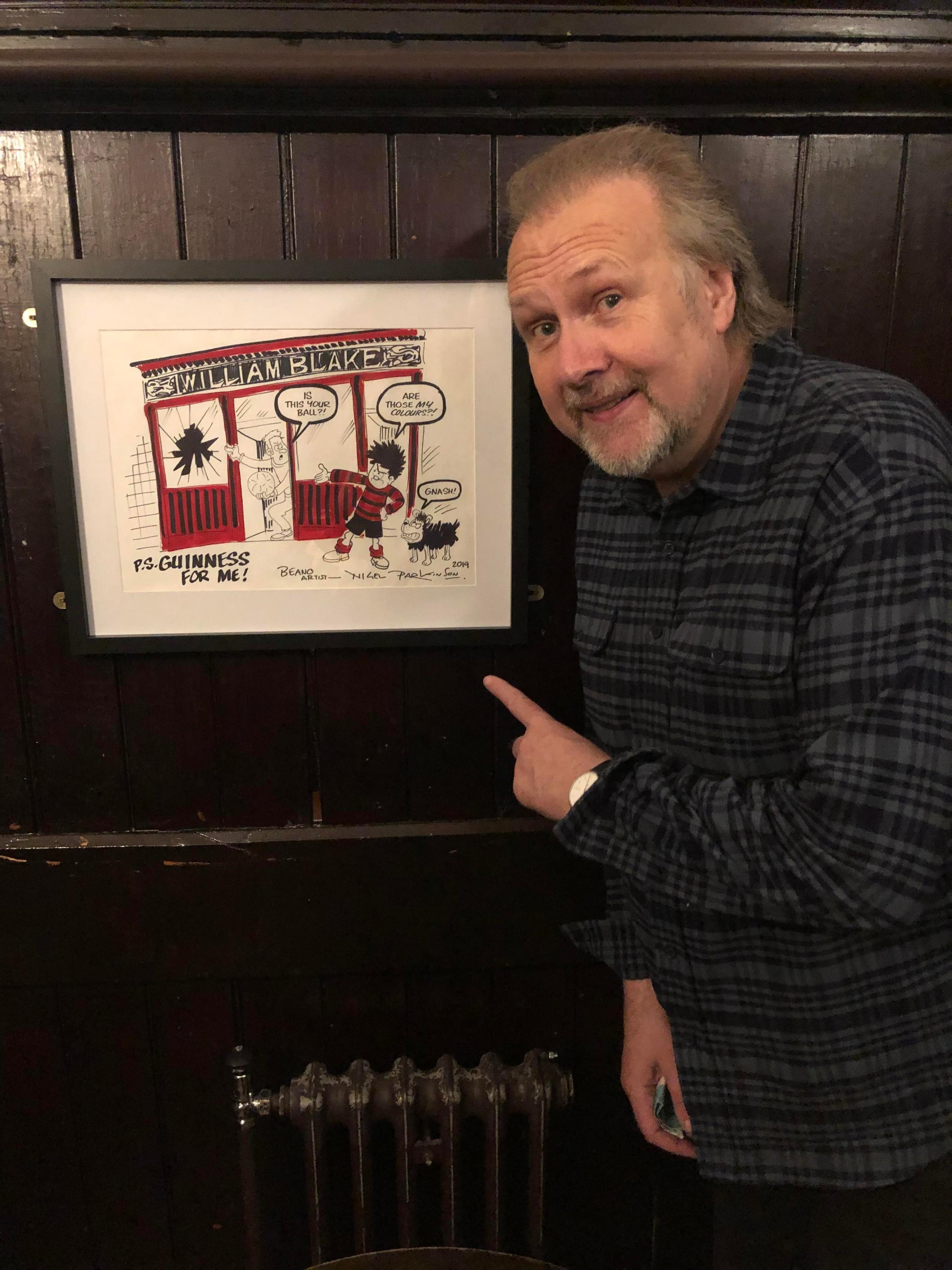 The Beano artist Nigel Parkinson pictured with his Blakes of the Hollow cartoon in situ.