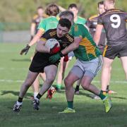 Odhran Johnstone fends of the challenge of Gary Maguire