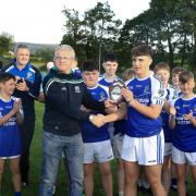 Eoghan Cassidy presents the Devenish captain, Daniel McGovern with the winners trophy