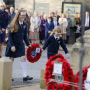 Children playing their part to help pay the community's respects at the war memorial.