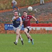Barry Mulrone fists the ball clear as Enda O'Connell closes in
