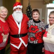 Attending the West End Tea Pots Christmas Coffee Morning are Margaret McGovern, Santa Claus, Rosie Crawford and June Livingstone.