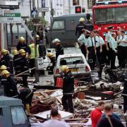 Police officers and firefighters inspecting the damage caused by the Omagh Bomb in 1998. Photo by Paul McErlane/PA Wire.