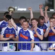 Martin Doherty lifts the trophy for Devenish.