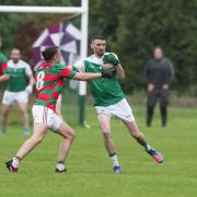 Niall Cosgrove fends of the challenge of Mark Kelly