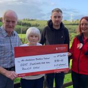 Harold and Joan Williamson, from Fivemiletown, pictured with their son, Lyle, presenting £810 to Air Ambulance Northern Ireland volunteer Hazel McClelland.