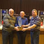 Harold Nixon and David Graham being presented with the Wesley Phair Pairs trophy by Jude Morris, representing the Phair family.