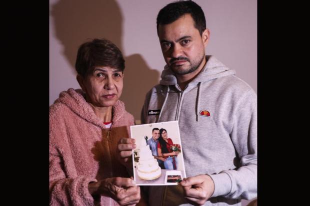 Marcelo Fernandes (husband), and her mother, Wanda, are pictured holding a picture of the late Valeria Amorim.