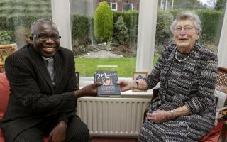 Mrs Joan Wilson presenting a book of her late daughter ''Marie'' to  The Rev. Dr. Sahr Yambasu President of The Methodist Church of Ireland at her home in Enniskillen.