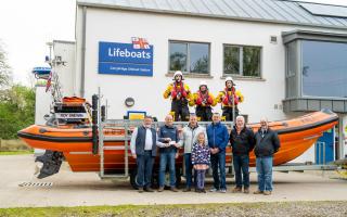 The £1,500 cheque being presented by the Erne Boat Rally Committee to the Carrybridge RNLI members. Photo: Stephen Scott, Carrybridge RNLI.